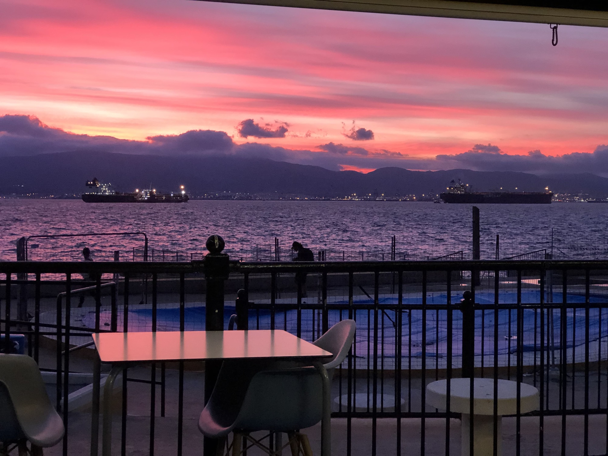 Dusk over Rosia Bay seen from a terrace table at Dolphin