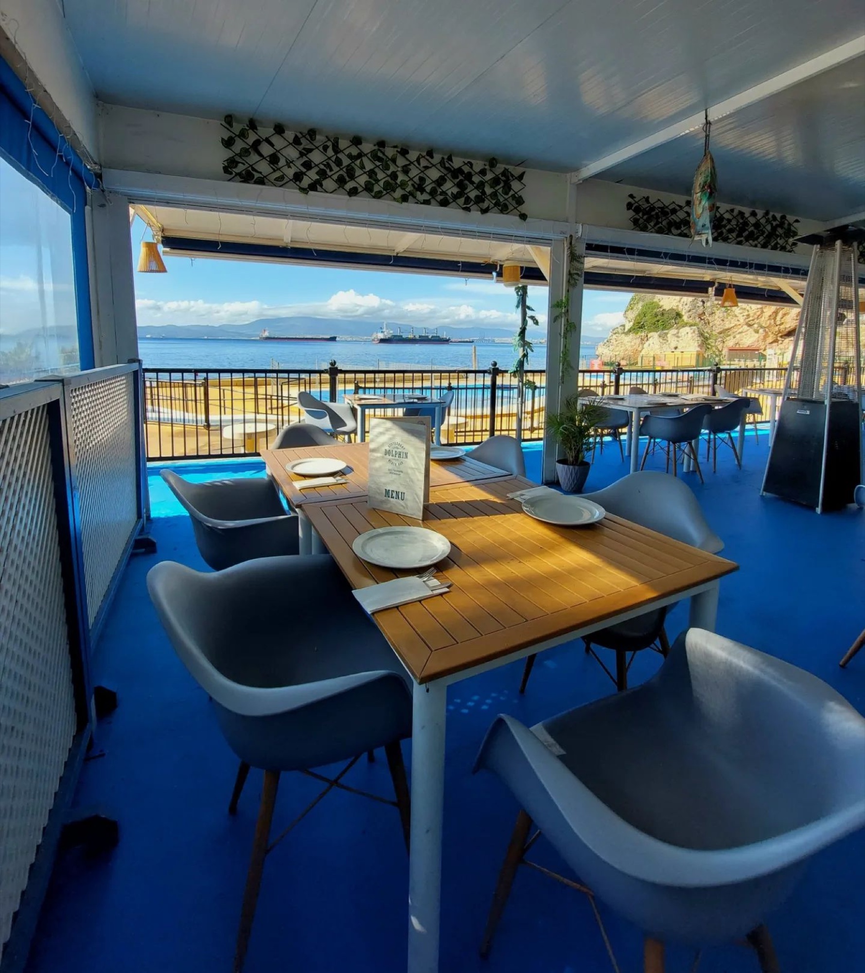 A set table on the terrace with the sea and the Rock behind